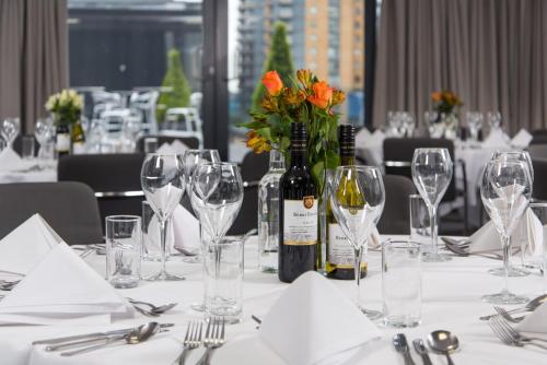 a table with glasses and a bottle of wine at Holiday Inn London West by IHG in London