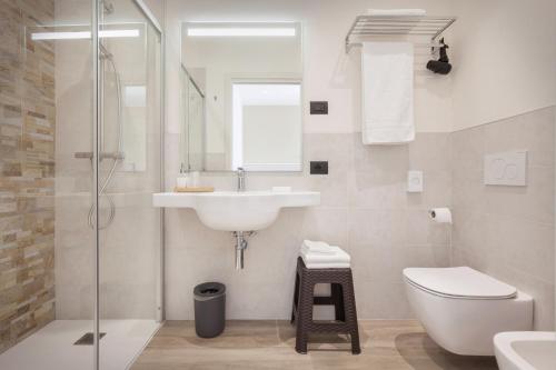 a white bathroom with a sink and a toilet at Le Betulle in Colà di Lazise