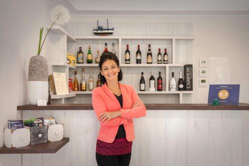 a woman standing in a bar with her arms crossed at Le Betulle in Colà di Lazise