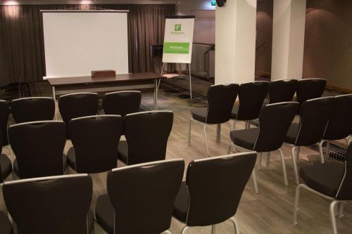 a conference room with chairs and a white screen at Holiday Inn Newcastle-Jesmond by IHG in Newcastle upon Tyne