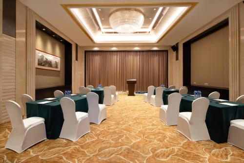 a conference room with tables and chairs and a podium at Holiday Inn Nanchang Riverside by IHG in Nanchang