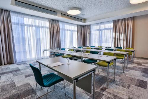 a conference room with tables and chairs and windows at Holiday Inn - Villingen - Schwenningen by IHG in Villingen-Schwenningen