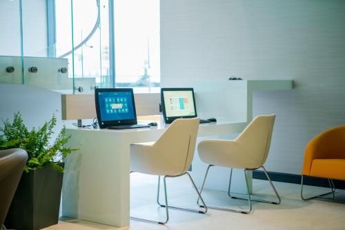 an office with three chairs and a desk with a laptop at Holiday Inn Dąbrowa Górnicza-Katowice by IHG in Dąbrowa Górnicza