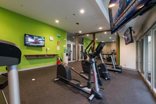 a gym with several tread machines in a room at Holiday Inn - Lima Airport by IHG in Lima