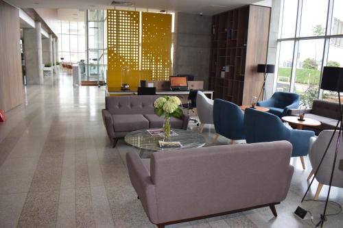 a lobby with couches and a table and chairs at Holiday Inn - Lima Airport by IHG in Lima