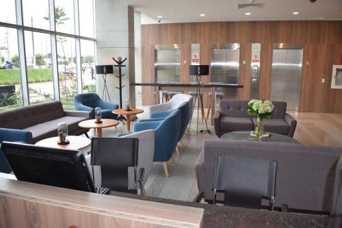 a waiting room with couches and tables and a lobby at Holiday Inn - Lima Airport by IHG in Lima