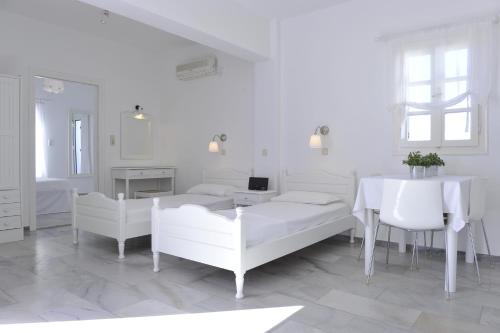 a white room with two beds and a table at Villa Irini in Naousa