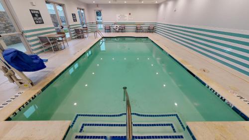 a swimming pool with green water in a building at Holiday Inn - NW Houston Beltway 8, an IHG Hotel in Houston