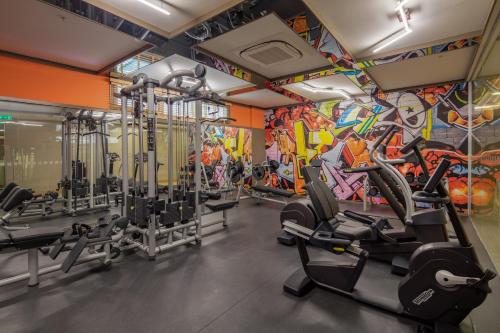 a gym with cardio equipment and a colorful wall at Holiday Inn Antalya - Lara by IHG in Antalya