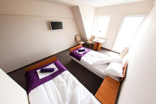 2 camas en una habitación de color púrpura y blanco en Lawendowy Ogród en Brzeg