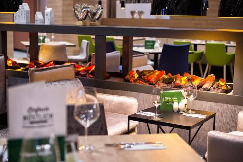 a restaurant with tables and chairs with wine glasses at Holiday Inn Frankfurt Airport by IHG in Frankfurt/Main