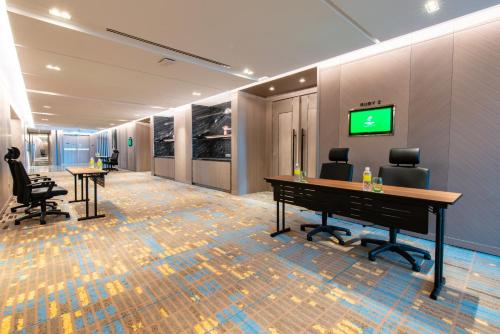an office with two desks and a tv on a wall at Holiday Inn Johor Bahru City Centre by IHG in Johor Bahru