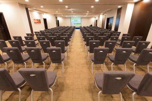 an empty room with chairs and a presentation at Holiday Inn Muscat AlSeeb by IHG in Muscat