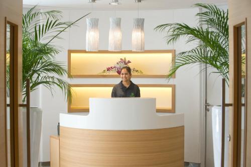 a woman standing behind a podium in front of a mirror at Holiday Inn Muscat AlSeeb by IHG in Muscat