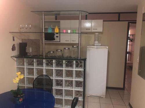 a kitchen with a refrigerator and a shelf with glasses at Atlântico Flat Apto 103 in Natal