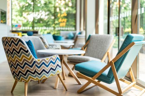a group of chairs and tables in a room at Holiday Inn Bournemouth by IHG in Bournemouth