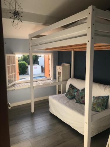 a bedroom with a bunk bed and a window at Le Gite de Fanny in Saintes-Maries-de-la-Mer