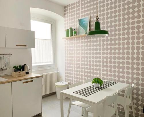 a kitchen with a table and a white table and chairs at Casa Strehler in Trieste