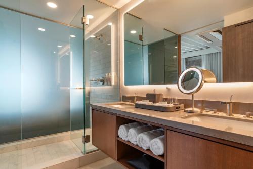 bagno con lavandino, doccia e specchio di One11 Hotel a New Orleans