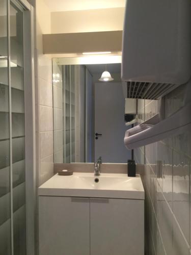 une salle de bain avec un lavabo et un miroir dans l'établissement Appartement centre ville près du port avec parking et wifi, à La Rochelle