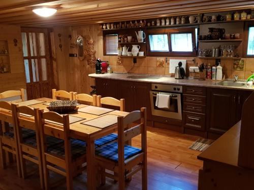 a kitchen with a wooden table and a table and chairs at Chata pod skalou in Valaská