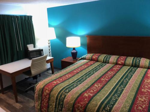 Habitación de hotel con cama, escritorio y silla en Econo Lodge en Georgetown