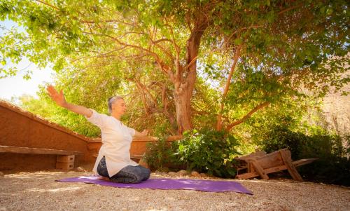a man sitting on a purple mat in front of a tree at Hotel Casona Distante in Alcoguaz