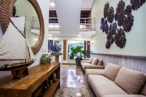 Una sala de estar con un barco pirata en la pared. en Ilhabela Beach Residences, en Ilhabela