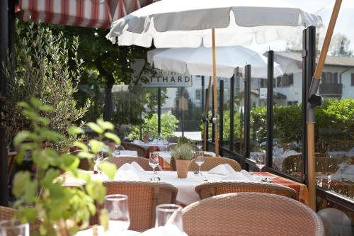 an outdoor table with a white umbrella and chairs at Seehotel Gotthard in Weggis