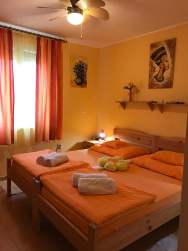 two beds in a bedroom with towels on them at Tó- Party Panoráma Panzió & Wellness in Kiszombor