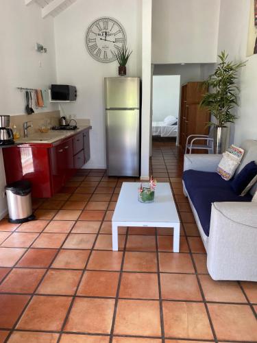 a kitchen and living room with a refrigerator and a table at cocon caraibe in Sainte-Anne