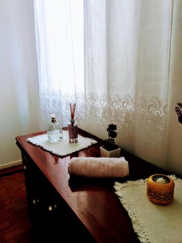 a bathroom with a wooden table with a window at Próximo ao Consulado - Quarto Inteiro in Porto Alegre