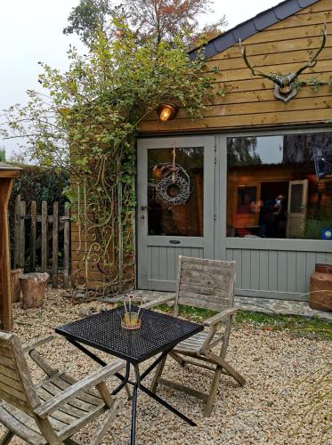 a patio with a table and two chairs in front of a house at Le Cerf d'Hubert in Redu