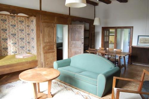 Appartement de charme au Manoir ! في Le Relecq-Kerhuon: غرفة معيشة مع أريكة زرقاء وطاولة