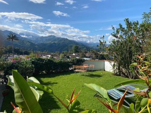 a garden with a table and a chair and mountains at Terrazas de Salento in Salento