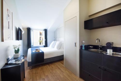 パリにあるスイート ＆ オテル エルゼー エトワールのベッドルーム1室(ベッド1台、シンク付)
