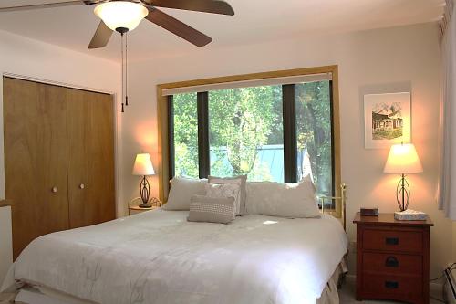 a bedroom with a white bed with a ceiling fan at Shadow Mountain Lodge in Aspen