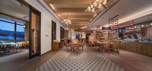 a restaurant with chairs and tables and a bar at Holiday Inn Jilin Beidahu by IHG in Jilin