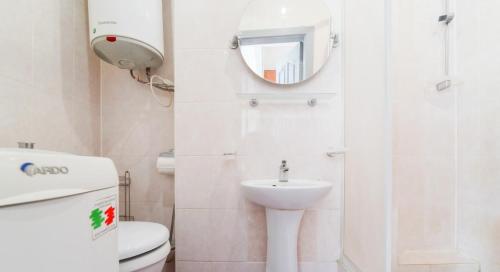 a bathroom with a toilet and a sink and a mirror at In the center of Minsk in Minsk
