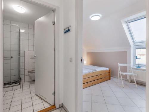 a bedroom with a bed and a bathroom with a shower at Charmante Ferienwohnung in Kirchdorf Insel Poel in Oertzenhof