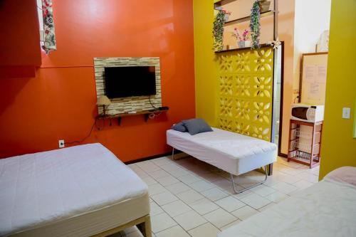 a room with two beds and a fireplace and a tv at CABANAS PARA ALUGUEL de TEMPORADA EM BOMBINHAS perto da praia in Bombinhas