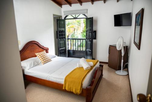 1 dormitorio con 1 cama, TV y ventana en Casa Rosales, en Medellín