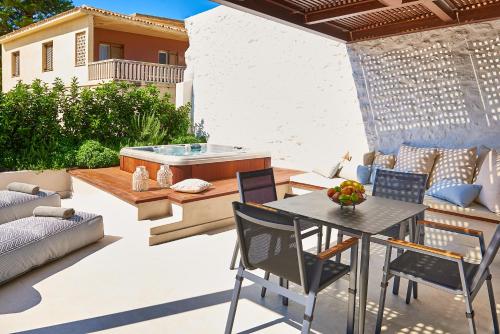 a patio with a table and chairs and a hot tub at Vista Del Porto Luxury Suites in Rethymno Town