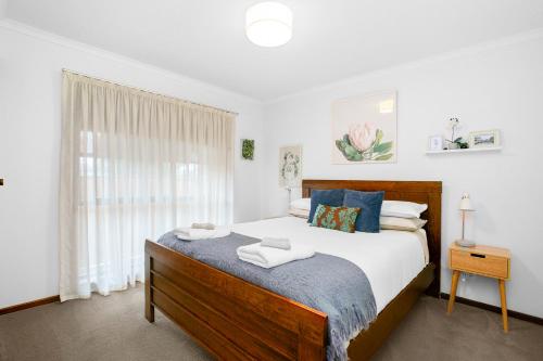 Un dormitorio con una cama grande y una ventana en Cosy Cottage 2BR, NETFLIX, Private Garden Terrace en Korumburra