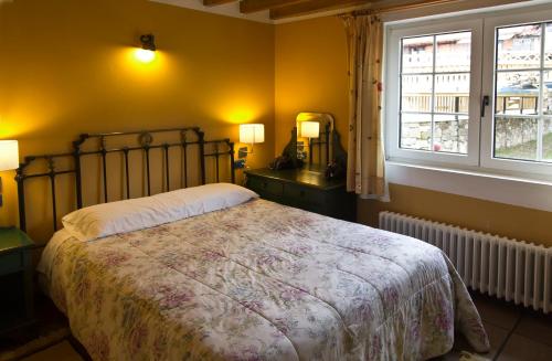a bedroom with a large bed and a window at Casa Rural Alquitara in Ojedo