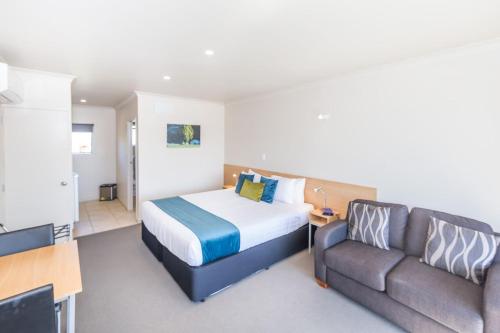 a hotel room with a bed and a couch at Taylors Motel in Ashburton