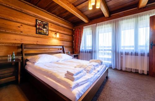1 dormitorio con 1 cama en una habitación con paredes de madera en Wille Trójca, en Trójca