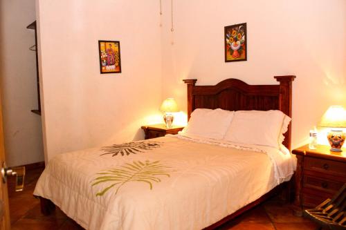 una camera con un letto con due comodini e due lampade di Hacienda Maria Elena a Tepoztlán