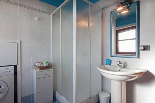 bagno bianco con lavandino e specchio di Confortevole appartamento in centro a LA MORRA a La Morra