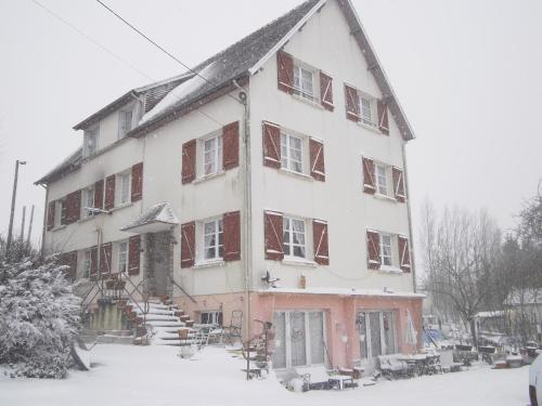 un gran edificio blanco con nieve. en Lenard Charles Bed & Breakfast, en Juvigny-sous-Andaine